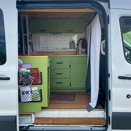 side view of a ford transit conversion van with green cabinets